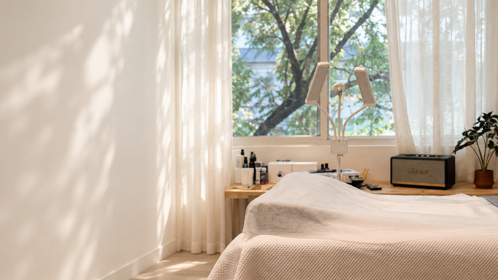 An editorial view adapted from Twinkle’s studio photograph, with soft daylight and an ivory treatment bed