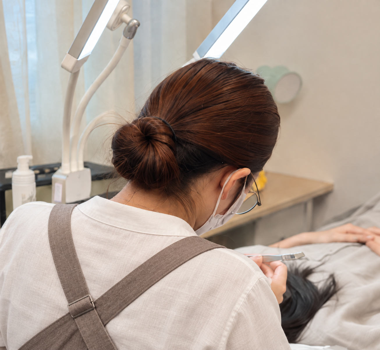 Illustrative work portrait of a lash artist in a taupe apron